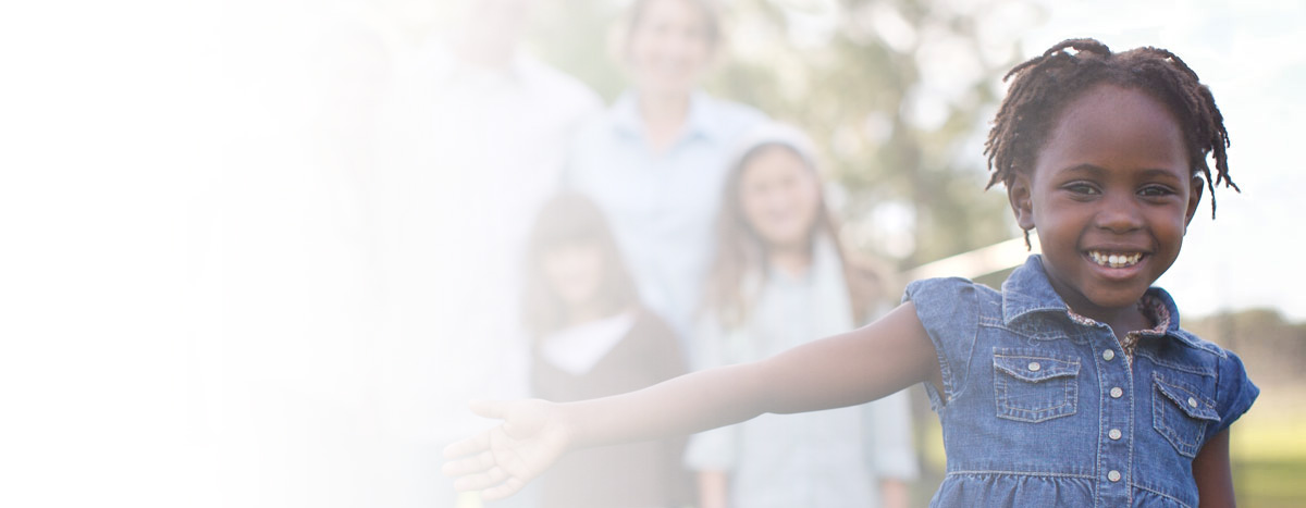 family blurred out in background with african-american girl in foreground